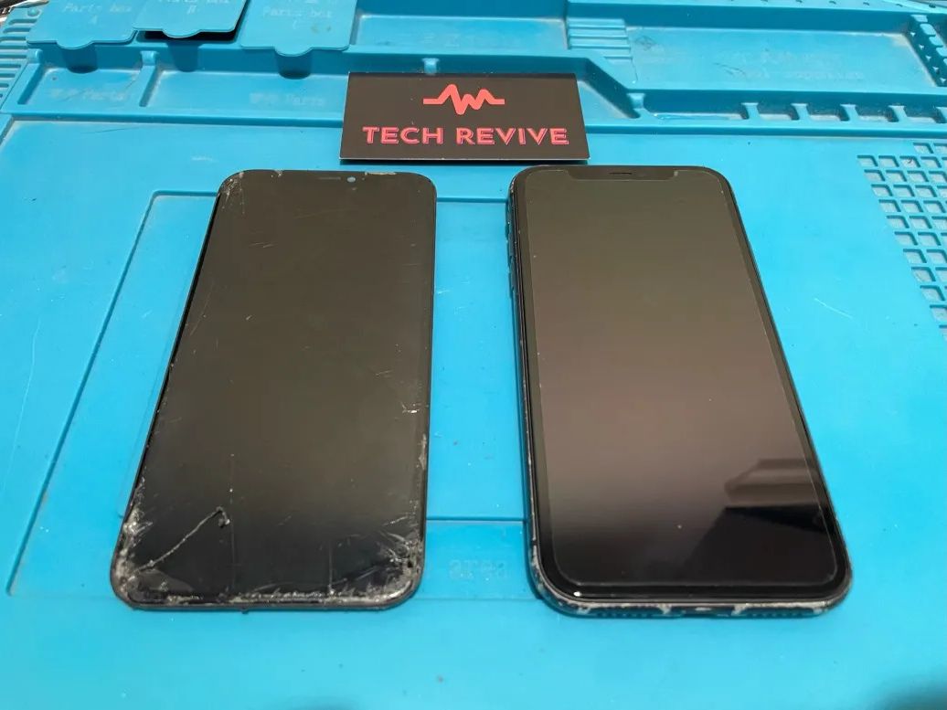 Two phones side by side on a blue repair mat, the left one with a cracked screen